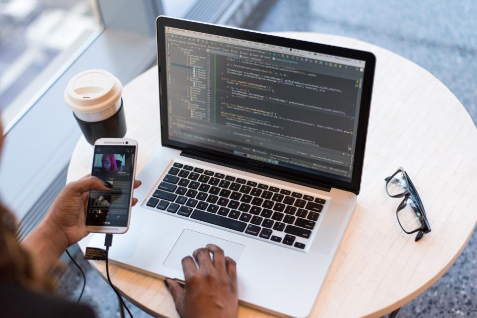 Person working across a laptop and phone