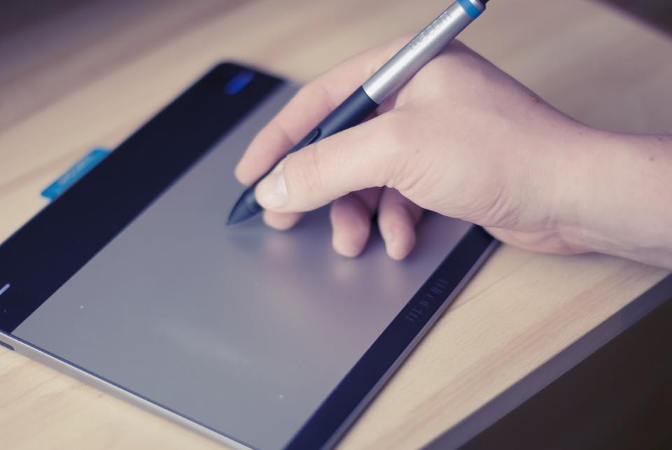 Designer using a stylus on a drawing tablet
