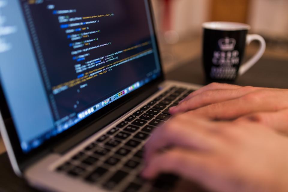Developer writing code on a laptop